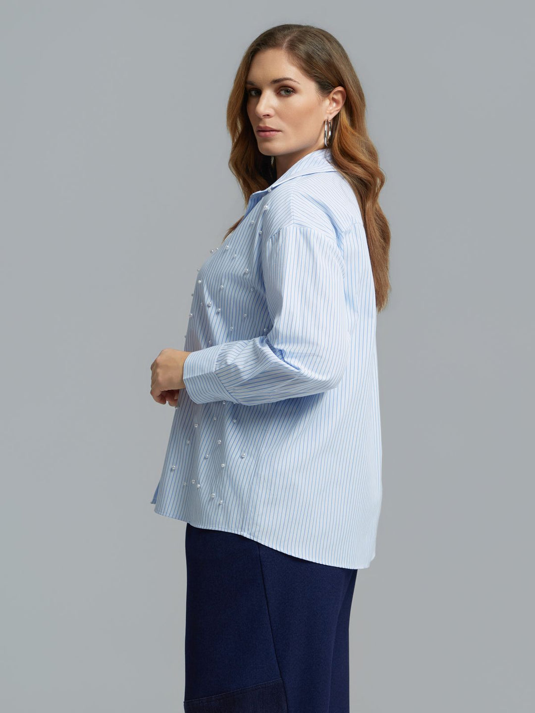 Light blue striped long sleeve button-front shirt with scattered pearl embellishments, side view on model