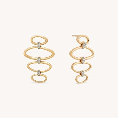 Gold-tone statement earrings with vertical spiral loops and white CZ stones, side view.
