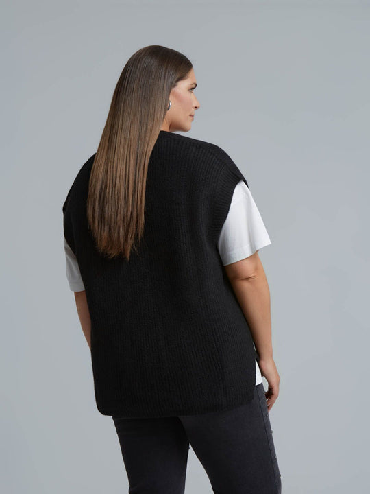 Black knit sweater vest worn over white tee, back view, relaxed fit