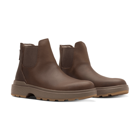 Pair of dark brown Kizik Sierra Chelsea boots with elastic gore and textured outsole.